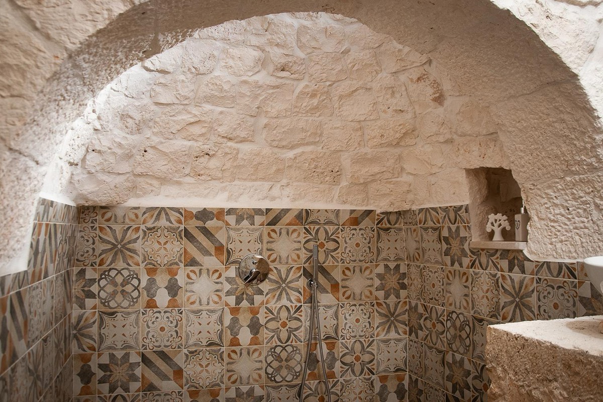 La doccia sotto l’arco del cono, con le piastrelle decorate